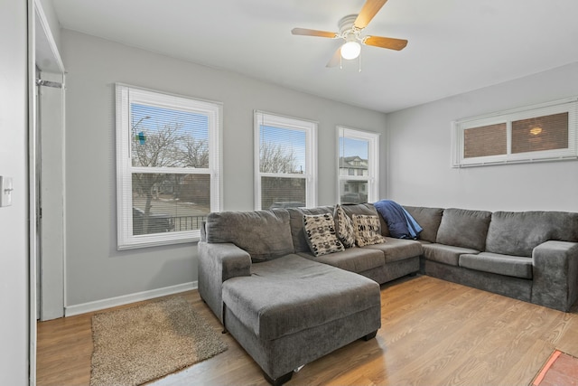 living room with light hardwood / wood-style floors and ceiling fan