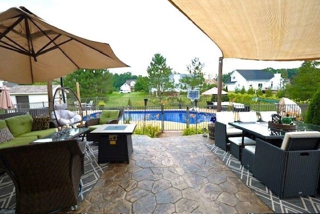 view of patio with a fenced in pool and an outdoor living space with a fire pit