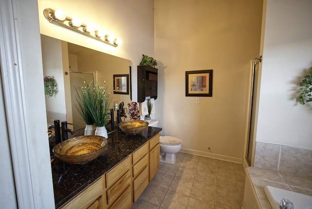 bathroom with tile patterned floors, toilet, a bathtub, and vanity