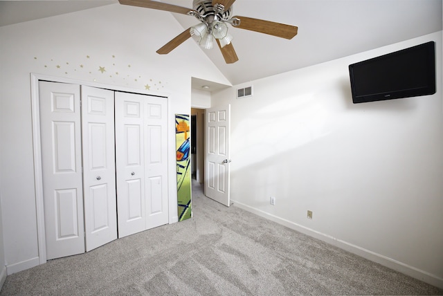 unfurnished bedroom featuring ceiling fan, light colored carpet, high vaulted ceiling, and a closet