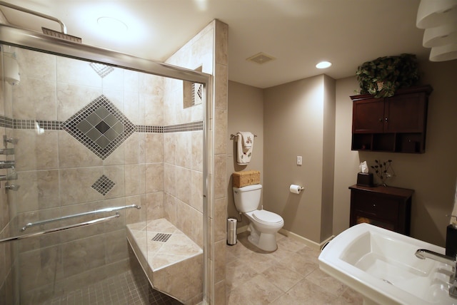 bathroom with tile patterned flooring, sink, a shower with door, and toilet