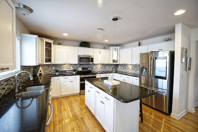 kitchen featuring stainless steel appliances, a kitchen island, and white cabinets