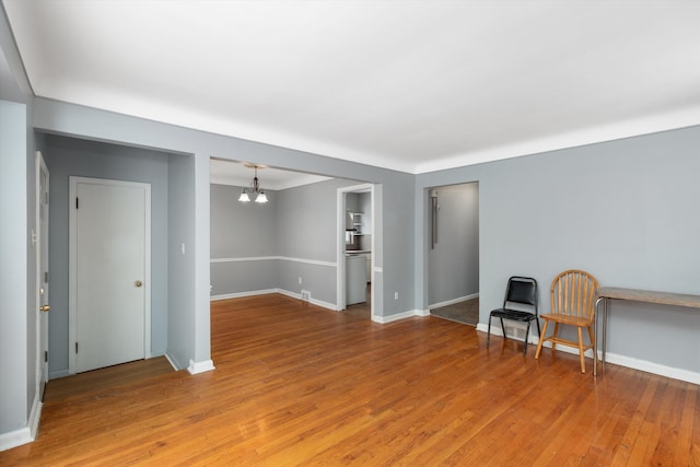 spare room with hardwood / wood-style floors and a notable chandelier