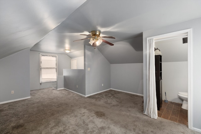 bonus room featuring dark colored carpet, vaulted ceiling, and ceiling fan