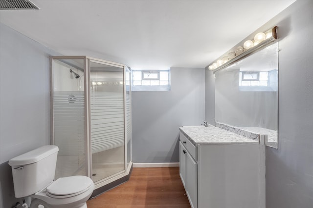 bathroom with vanity, a healthy amount of sunlight, hardwood / wood-style floors, and toilet