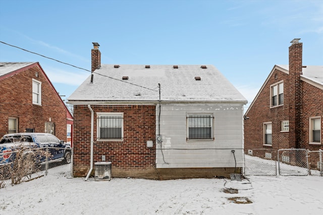 snow covered house with central air condition unit