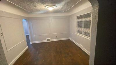 empty room featuring dark hardwood / wood-style flooring and a textured ceiling