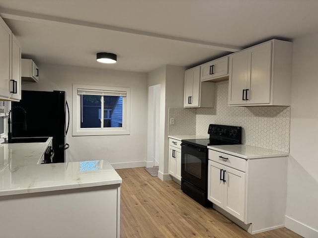 kitchen with white cabinets, light wood-type flooring, decorative backsplash, and black appliances