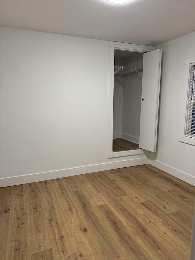 unfurnished bedroom with wood-type flooring and a closet