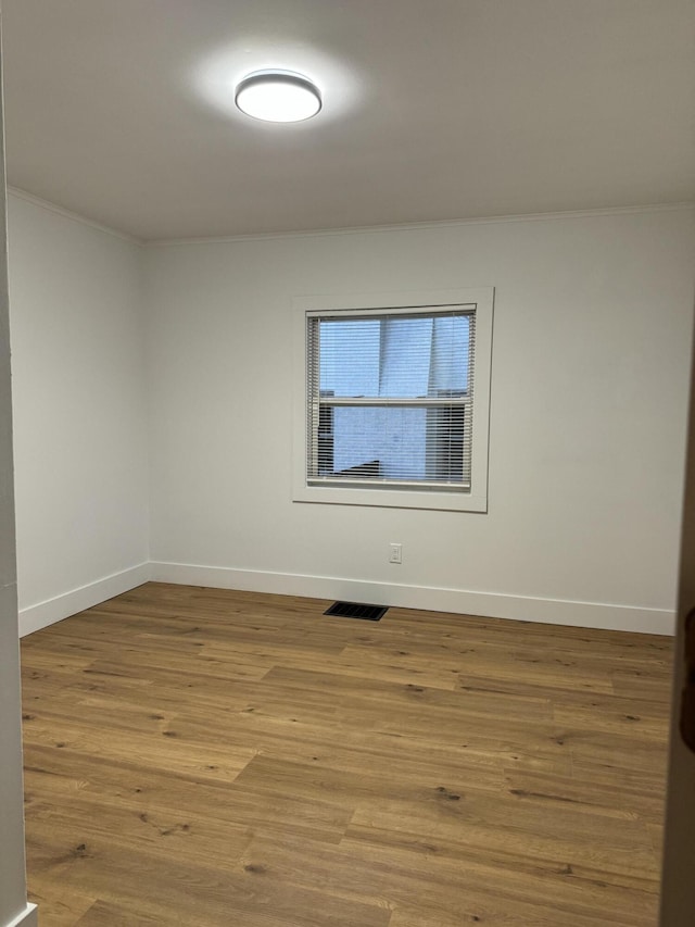 empty room featuring ornamental molding and light hardwood / wood-style floors