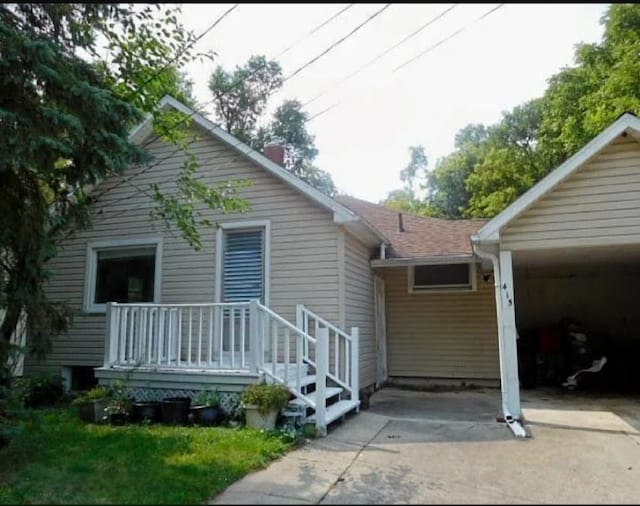 back of house featuring a carport