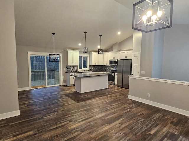 kitchen featuring an inviting chandelier, decorative light fixtures, stainless steel appliances, decorative backsplash, and white cabinets