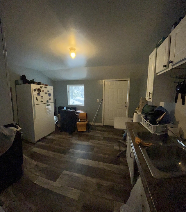 kitchen with white refrigerator, dark hardwood / wood-style floors, sink, and white cabinets