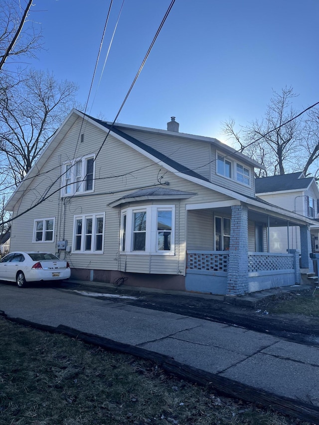 view of front of property with covered porch and a chimney