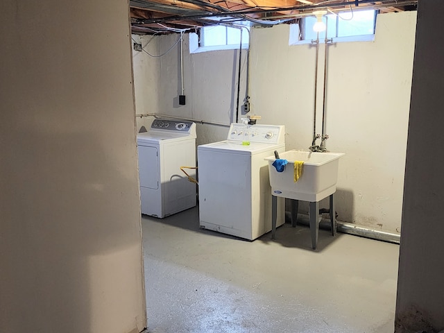 laundry area with a wealth of natural light, a sink, laundry area, and washer and clothes dryer