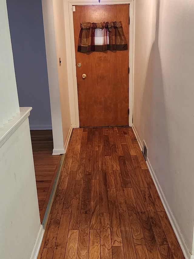 hallway featuring baseboards and wood finished floors