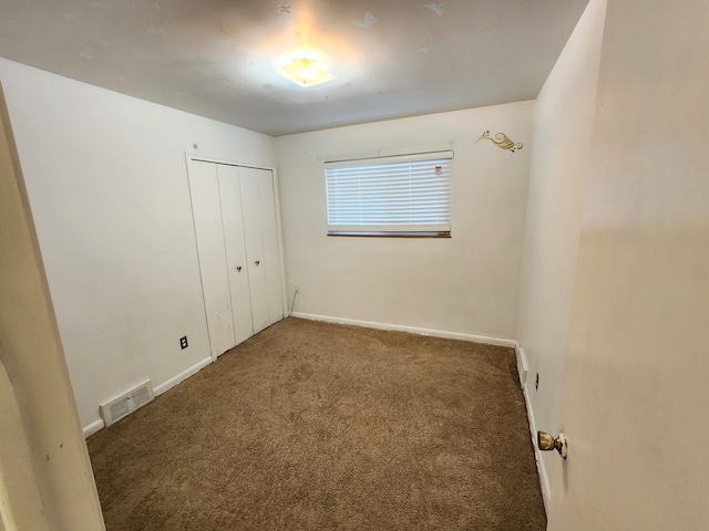 unfurnished bedroom with visible vents, baseboards, carpet, and a closet