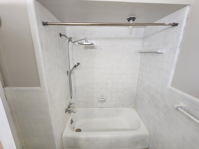 full bathroom with  shower combination, tile walls, and a wainscoted wall