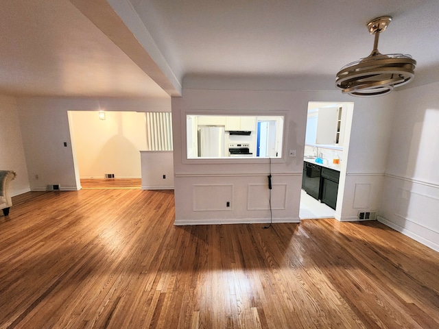 interior space featuring visible vents, range with electric cooktop, wood finished floors, and range hood