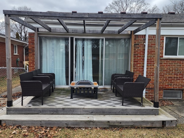 back of property with brick siding, a pergola, a deck, and fence