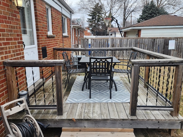 wooden deck with outdoor dining space and fence