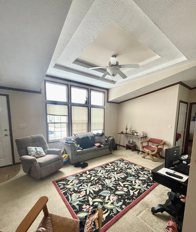 carpeted living room featuring a raised ceiling, ceiling fan, and a textured ceiling