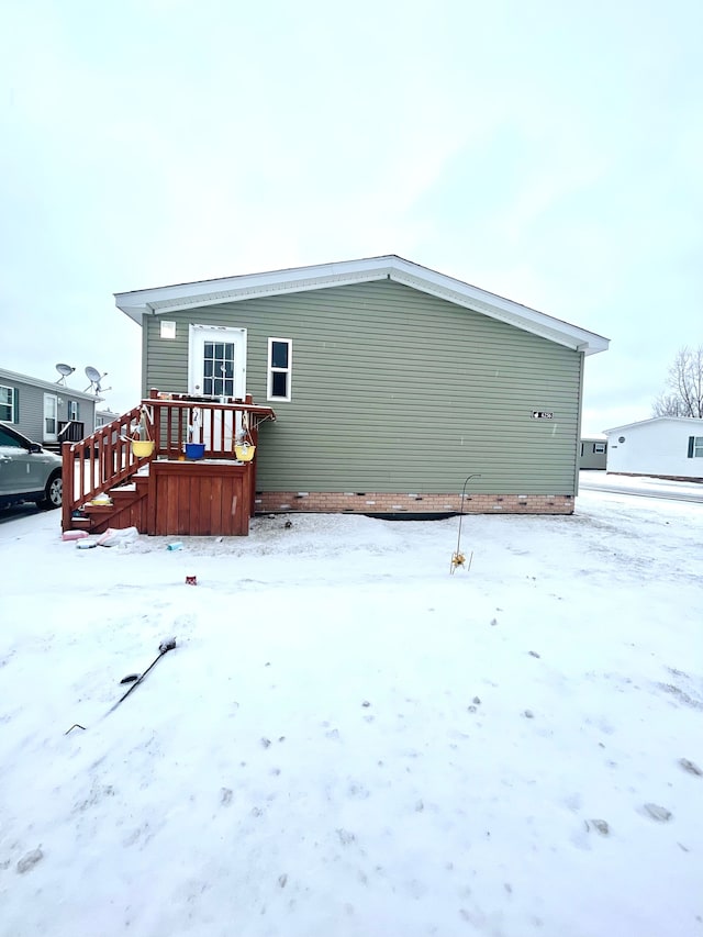 snow covered house with a wooden deck