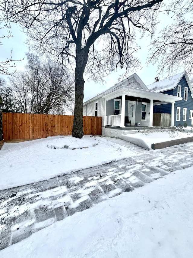 snow covered property featuring covered porch