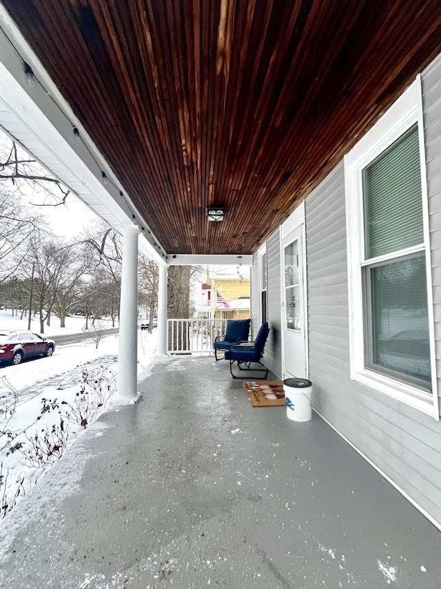 snow covered patio featuring a porch