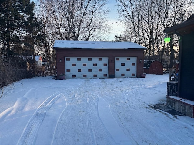 snow covered garage with a detached garage