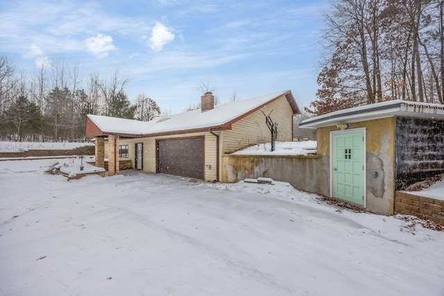 exterior space featuring a chimney and an attached garage