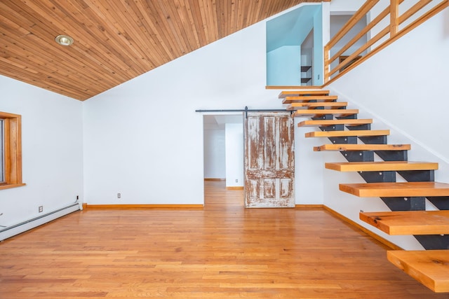 staircase with hardwood / wood-style flooring, baseboard heating, high vaulted ceiling, wooden ceiling, and a barn door