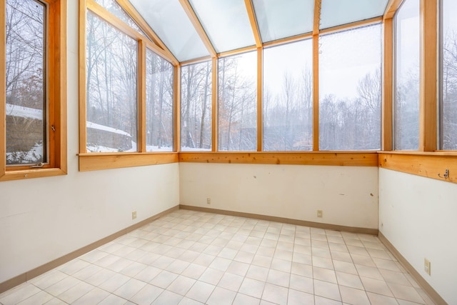 unfurnished sunroom featuring vaulted ceiling and a healthy amount of sunlight