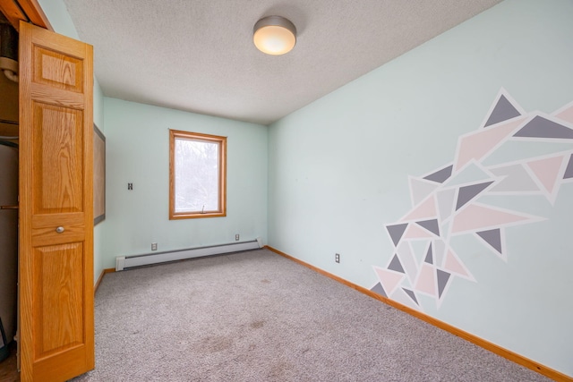 unfurnished room with carpet, a baseboard heating unit, and a textured ceiling