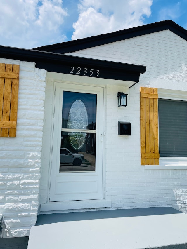 view of exterior entry with brick siding