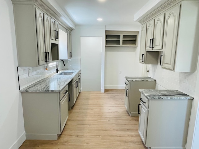 kitchen featuring light wood-style floors, gray cabinets, and a sink