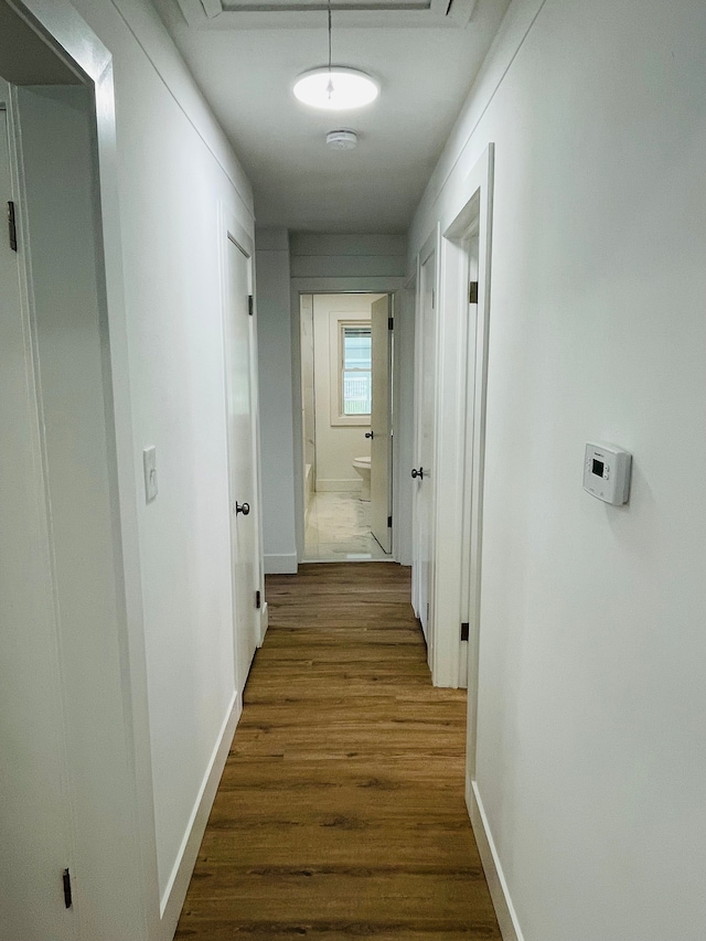 corridor featuring dark wood-style floors and baseboards