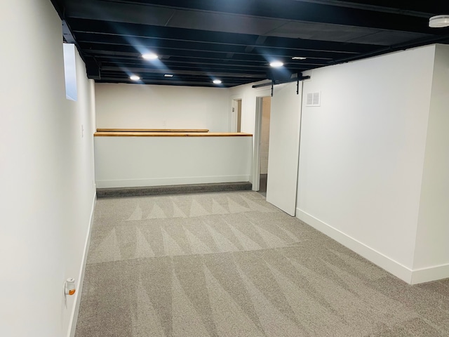 finished basement featuring carpet floors, visible vents, and baseboards