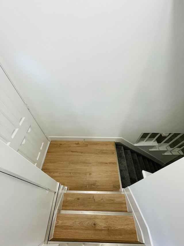 stairs featuring baseboards and wood finished floors