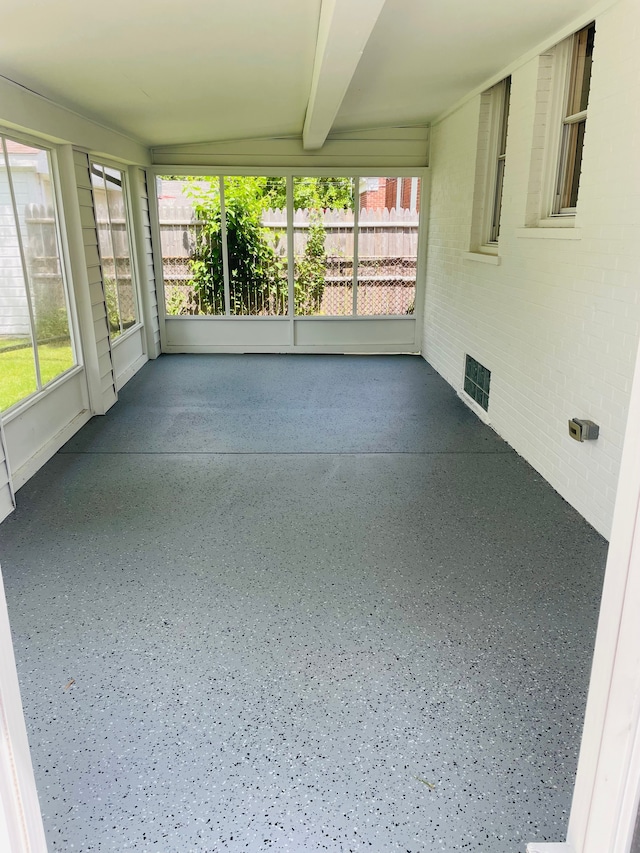 unfurnished sunroom featuring beamed ceiling