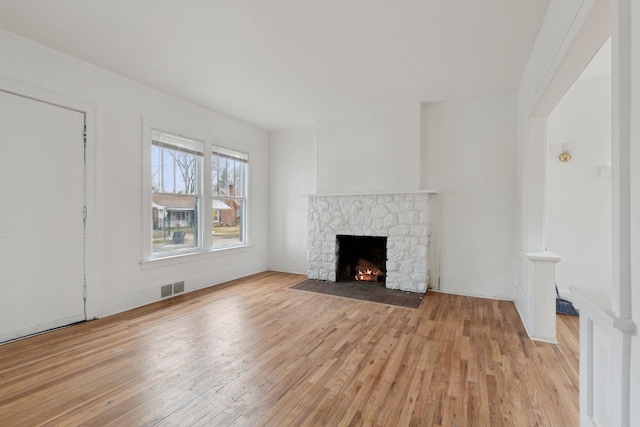 unfurnished living room featuring a fireplace and light hardwood / wood-style flooring