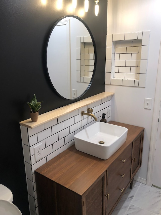 bathroom featuring vanity and backsplash