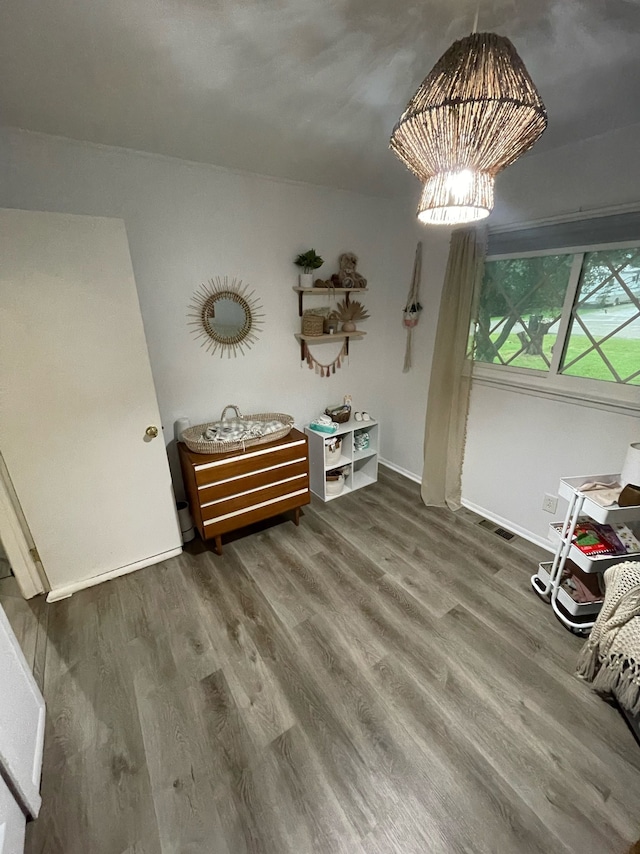 unfurnished dining area featuring an inviting chandelier and hardwood / wood-style floors