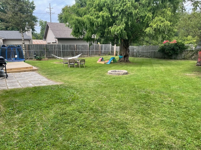 view of yard featuring a playground and a trampoline