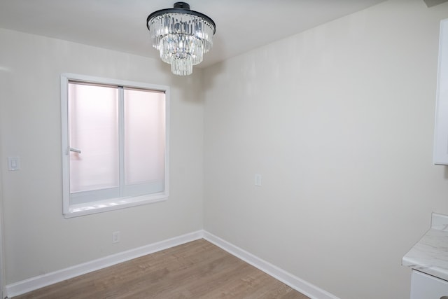 unfurnished dining area with light hardwood / wood-style floors and a chandelier