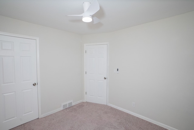 carpeted spare room featuring ceiling fan