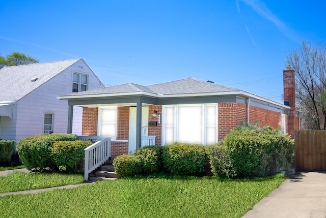 8679 Burt Rd, Detroit, MI 48228 - bungalow-style house with brick siding, covered porch, and a front lawn