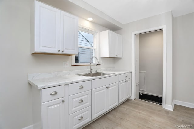 8679 Burt Rd, Detroit, MI 48228 - kitchen featuring a sink, baseboards, white cabinets, and light wood finished floors
