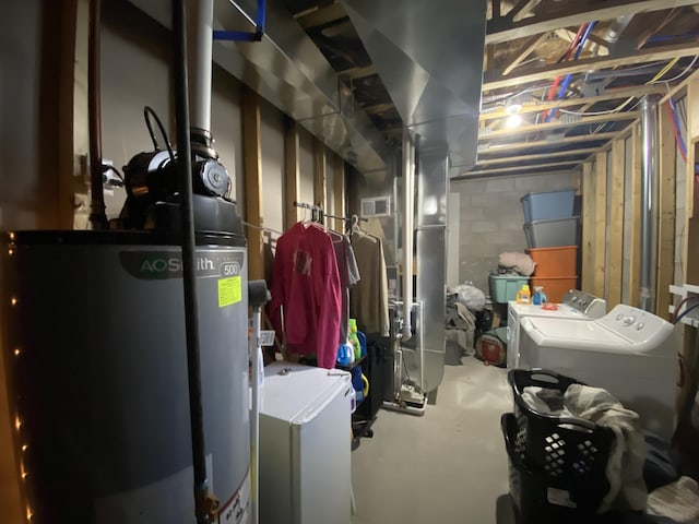 basement featuring washing machine and dryer and water heater