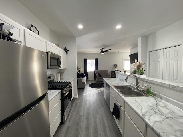 kitchen featuring sink, ceiling fan, appliances with stainless steel finishes, white cabinets, and dark hardwood / wood-style flooring